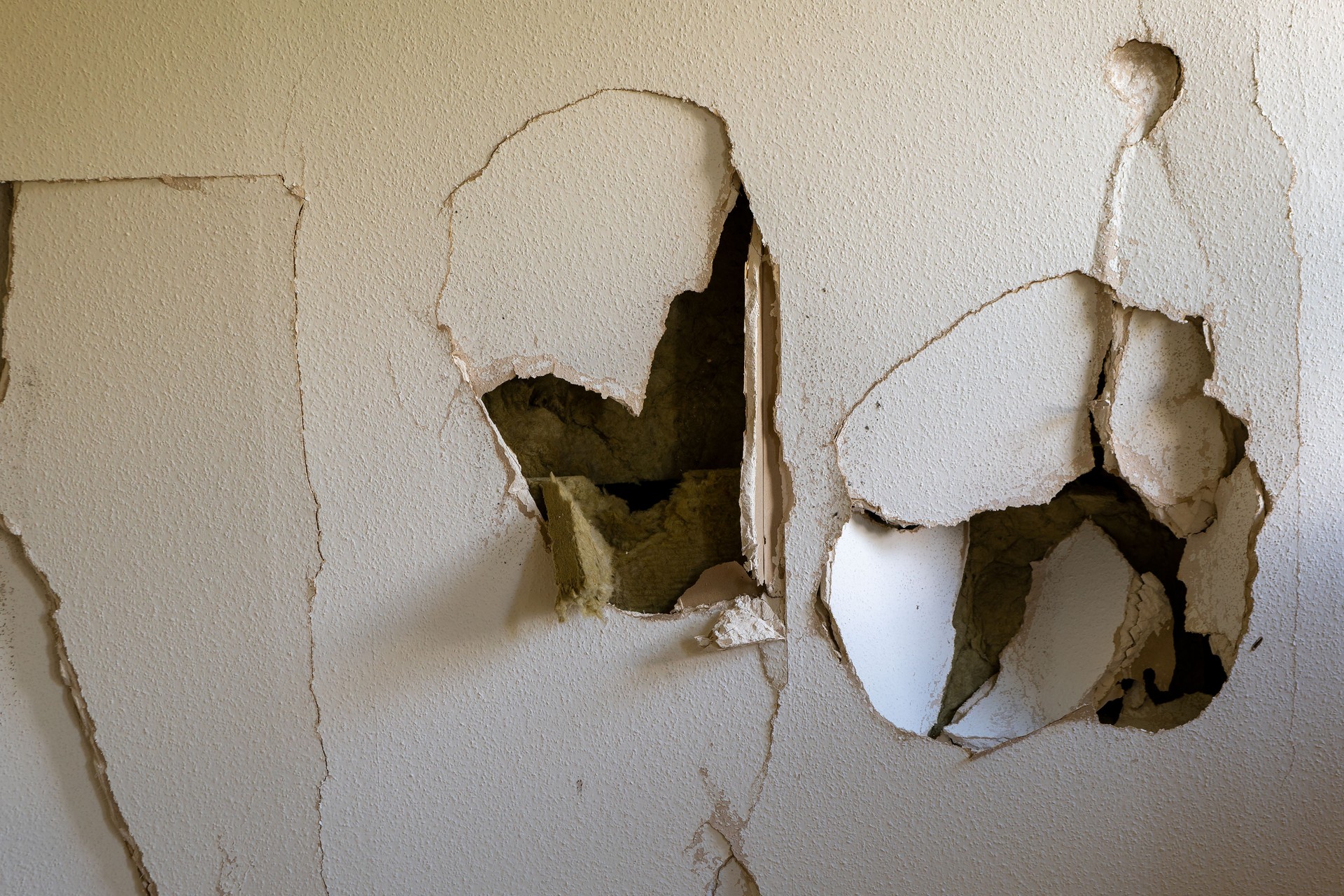 an old plasterboard wall with holes